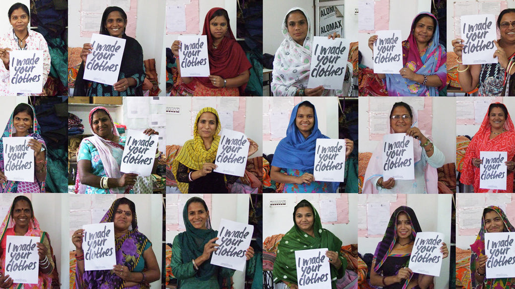 Eighteen artisan women, each holding a sign that says I made your clothes