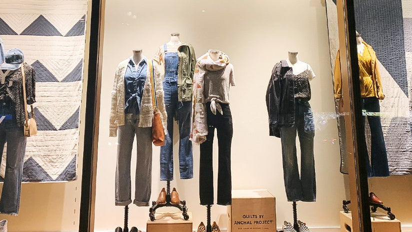 One of Anchal's artisan-made organic cotton quilts hanging in a Madewell storefront display