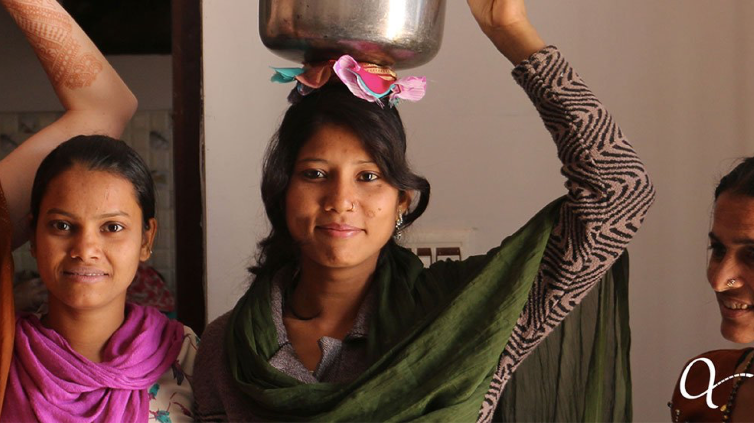 Anchal artisan woman holding a metal bowl on top of her head preparing to enter a workshop on entrepreneurship