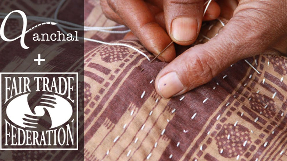Hand sewing an intricate pattern into brown fabric with Anchal and Fair Trade Federation logos overlaid to celebrate the acceptance of Anchal Project into the Fair Trade Federation