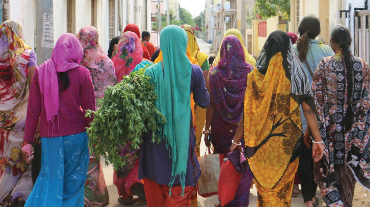 Women walking down the street in various colorful saris