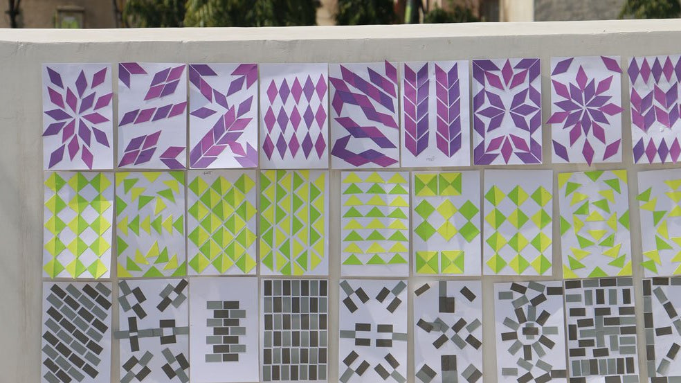 Twenty-seven sheets of unique patterned artwork categorized into three rows of color, purple, yellow and green, and black and grey