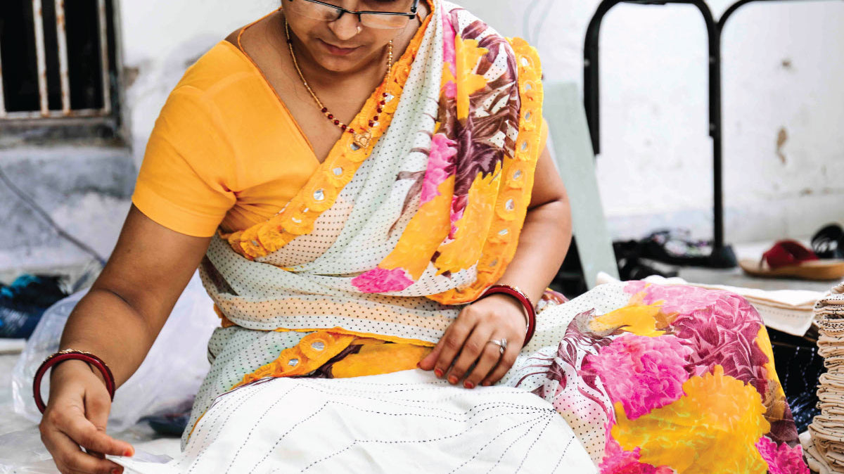 Anchal artisan hand sewing a pattern into a quilt