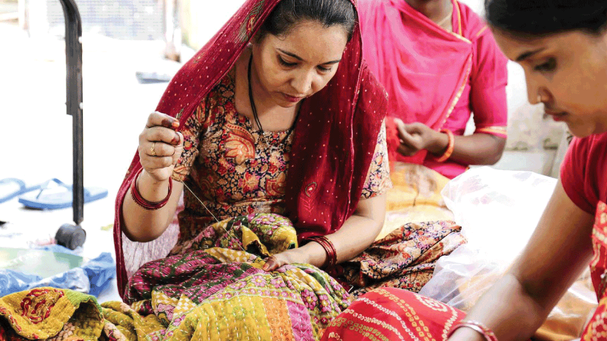 Artisan working on the hand stitching on a Kantha quilt