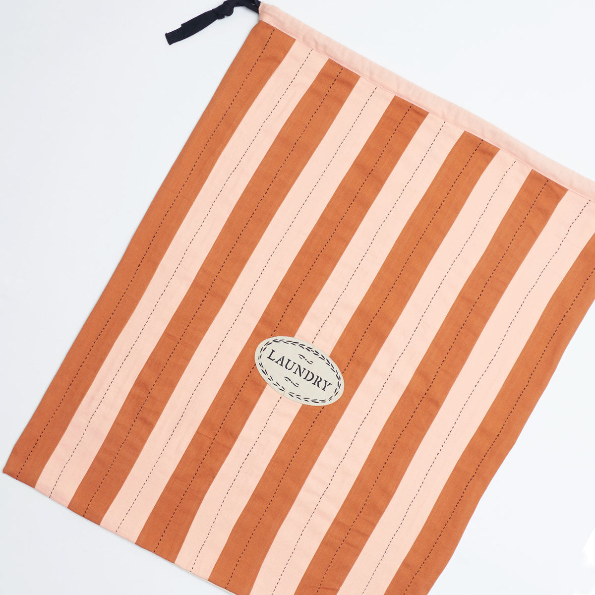 Ace Hotel x Anchal custom laundry bag in a pink and camel brown striped print with drawstring closure