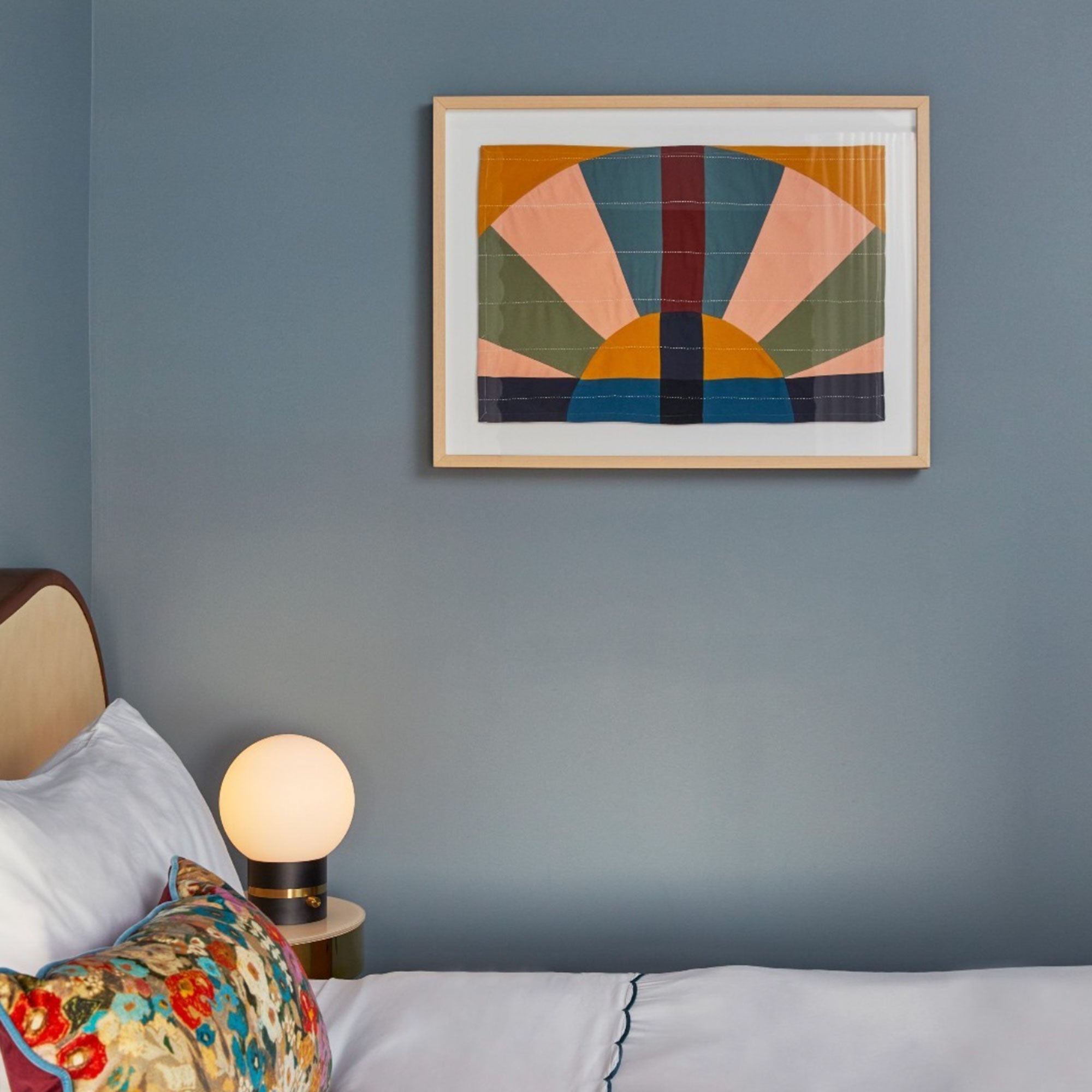 colorful framed textile artwork hanging on light blue wall in a hotel room in Louisville, KY