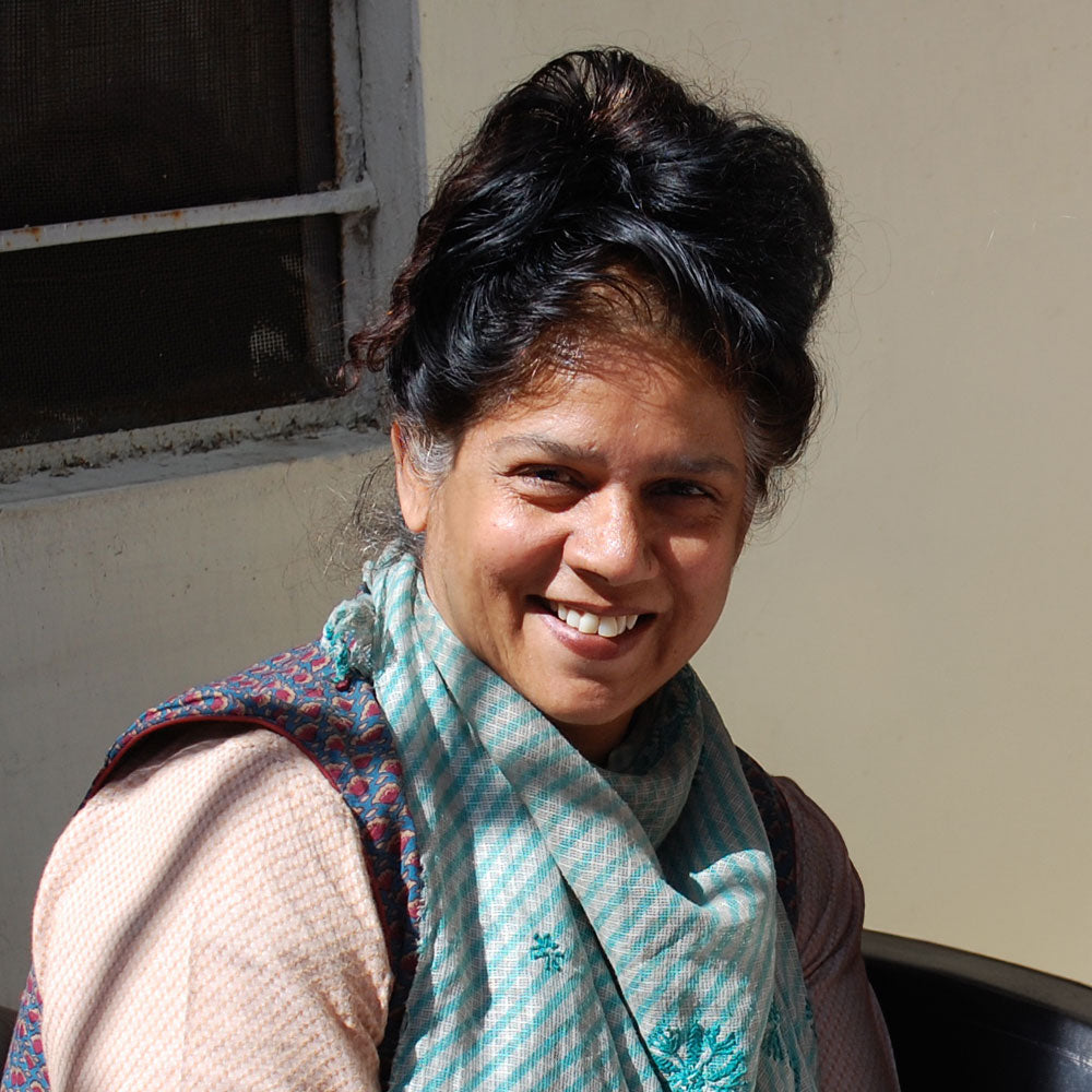 Woman wearing a colorful scarf and smiling outdoors, Jaimala, NGO Founder