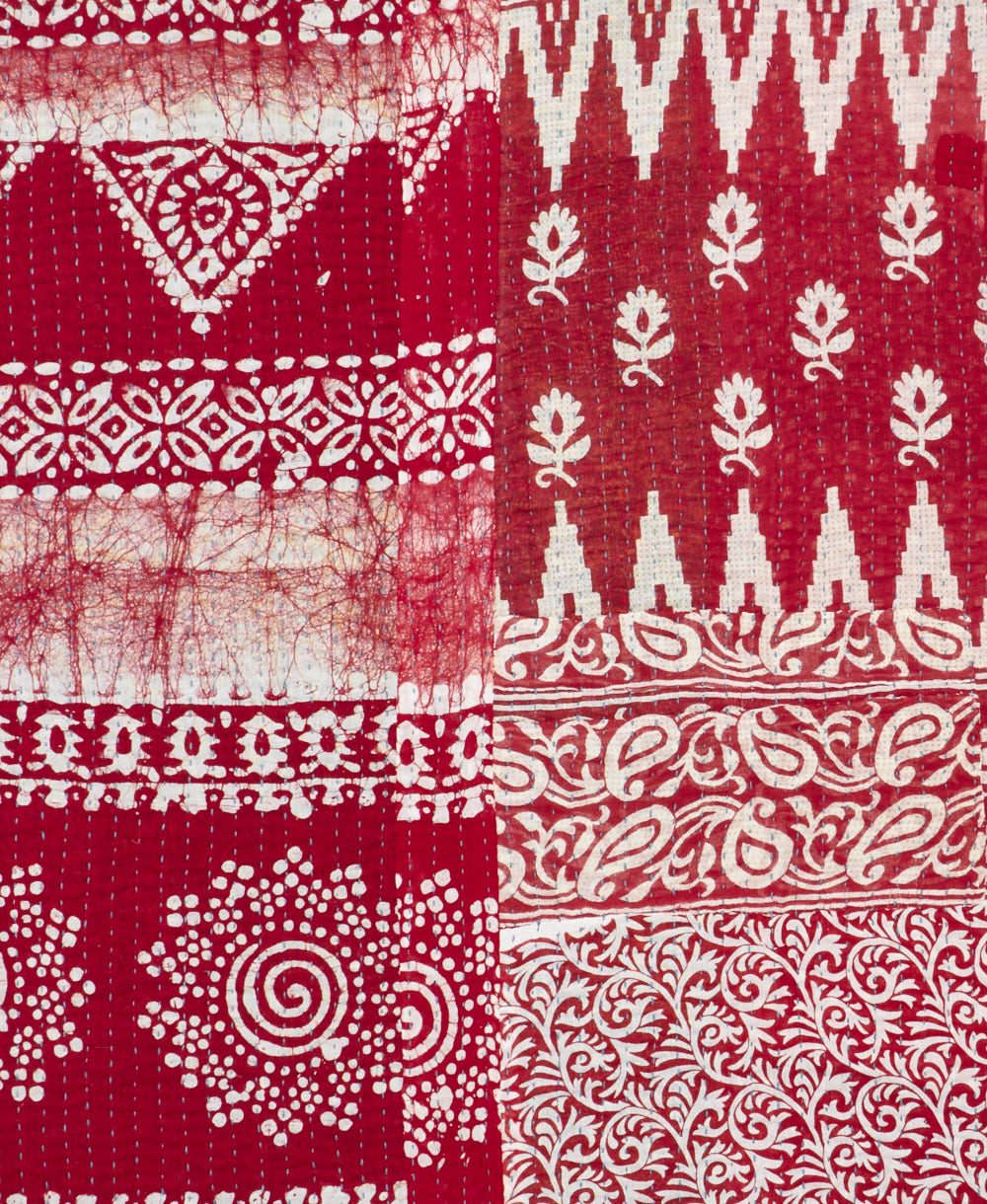 kantha quilt throw with a tag featuring the hand-stitched signature of the maker