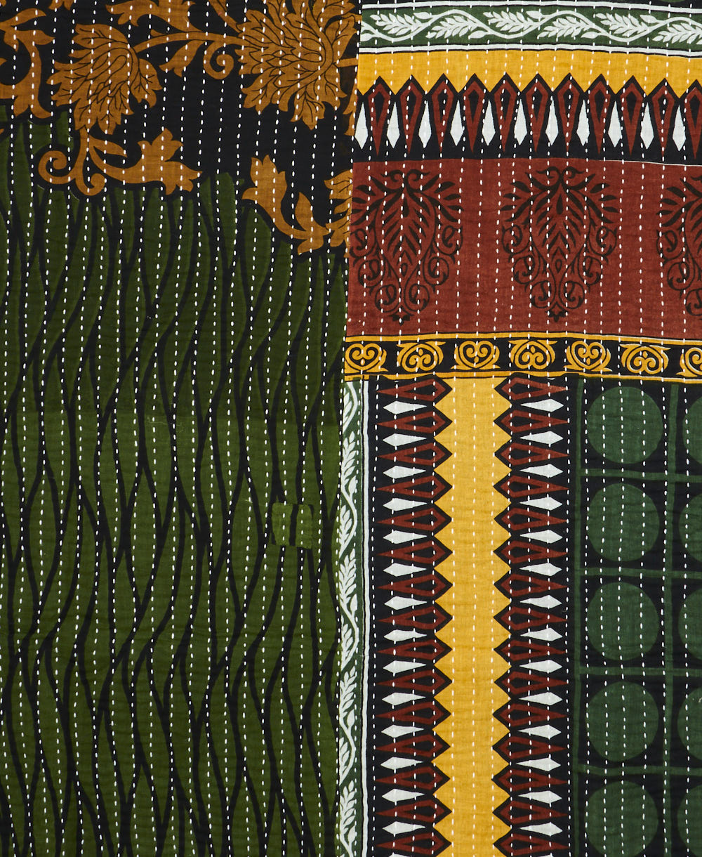 kantha quilt throw with a tag featuring the hand-stitched signature of the maker