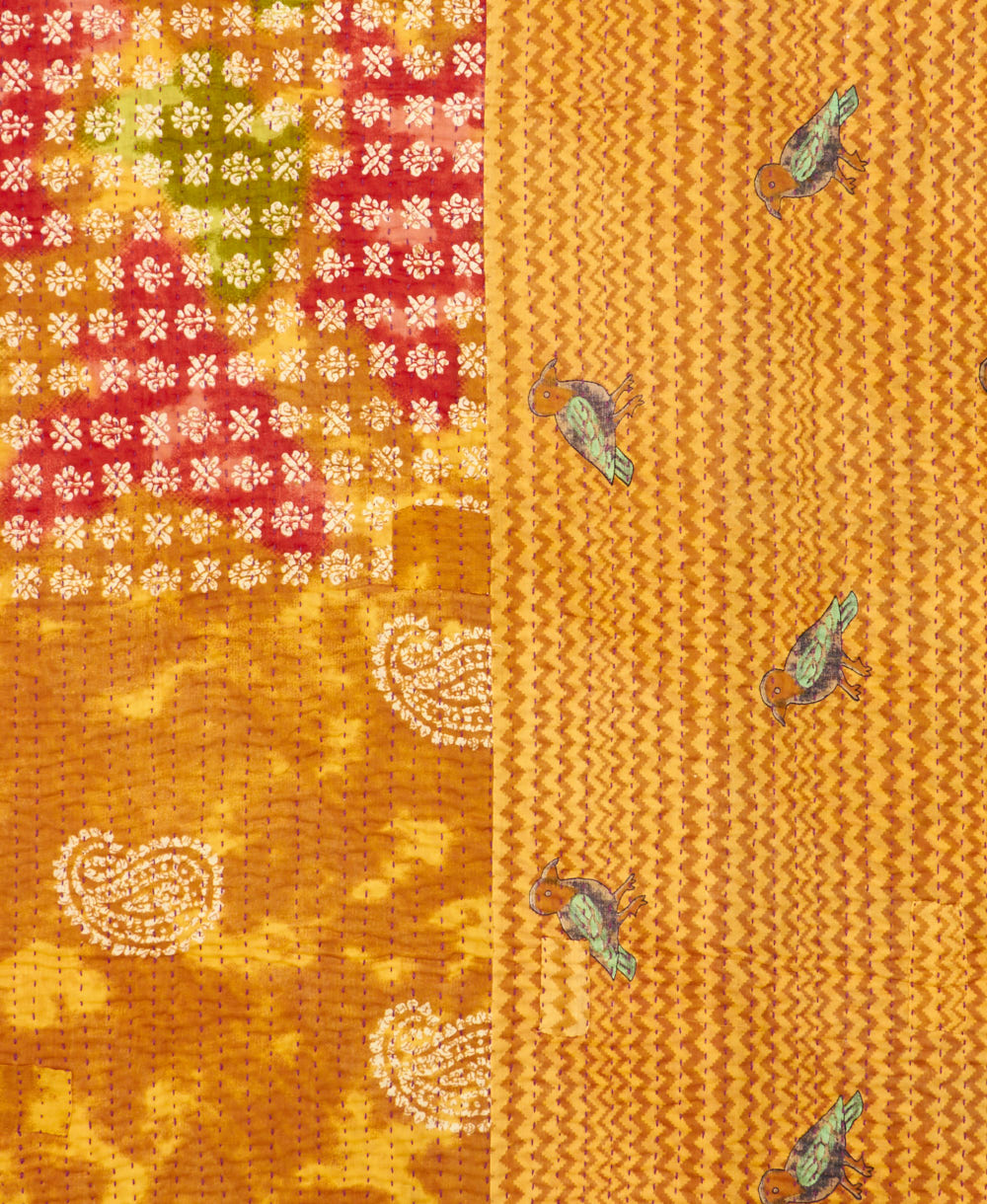 kantha quilt throw with a tag featuring the hand-stitched signature of the maker