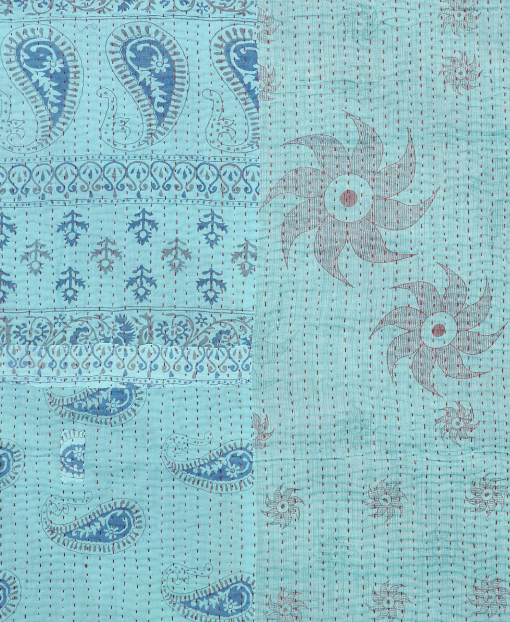 kantha quilt throw with a tag featuring the hand-stitched signature of the maker