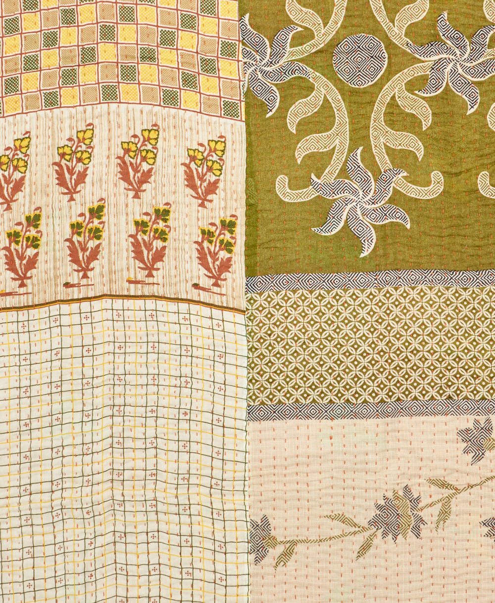 kantha quilt throw with a tag featuring the hand-stitched signature of the maker