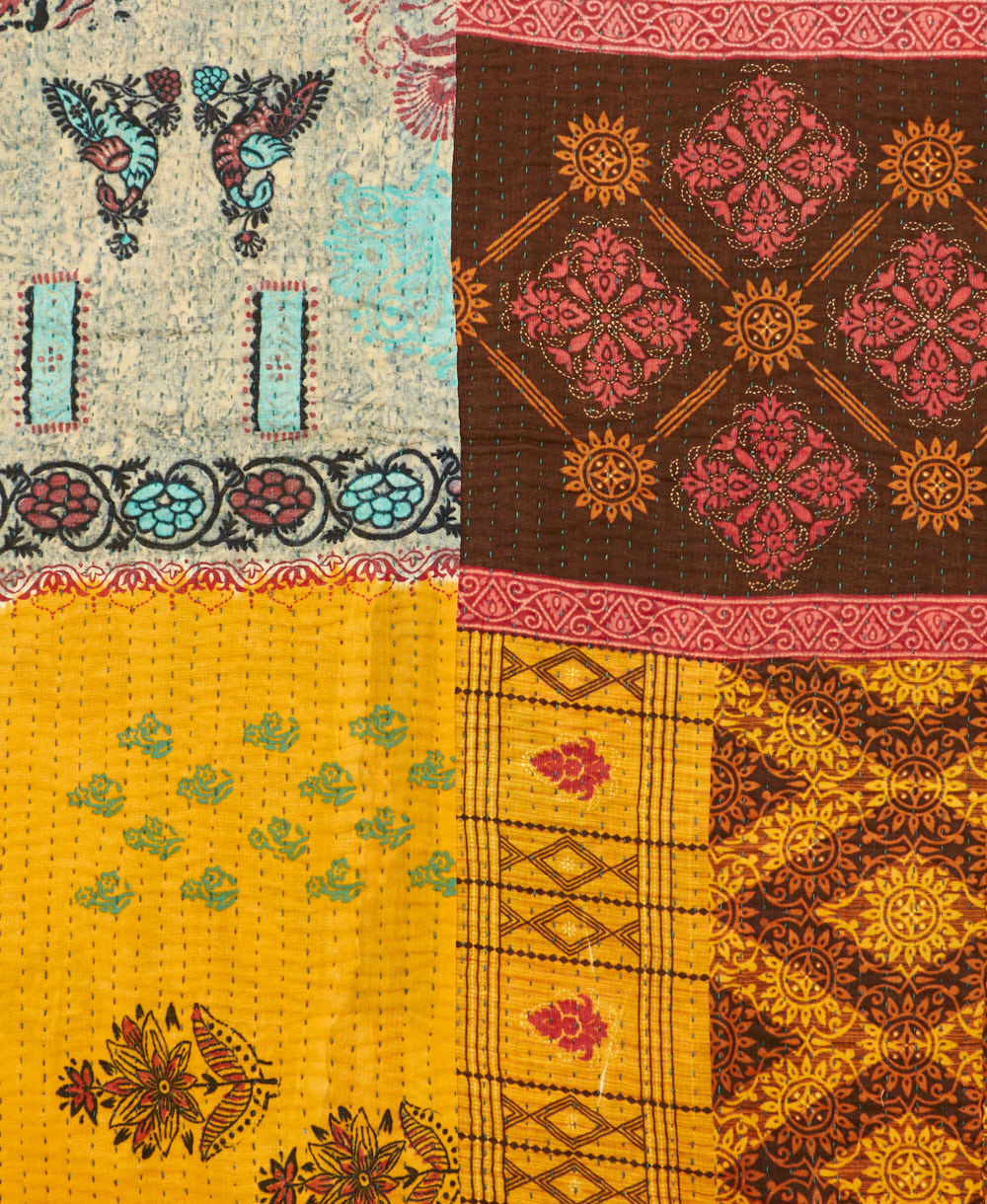 kantha quilt throw with a tag featuring the hand-stitched signature of the maker