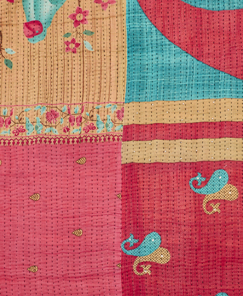 kantha quilt throw with a tag featuring the hand-stitched signature of the maker