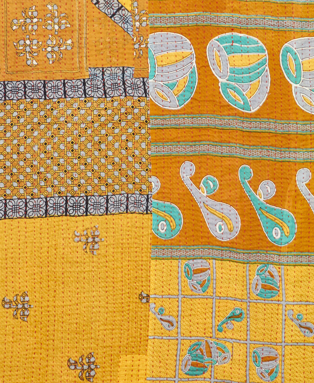 kantha quilt throw with a tag featuring the hand-stitched signature of the maker