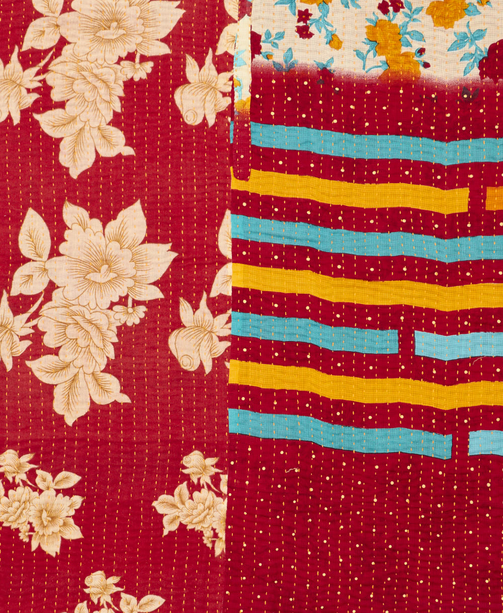 kantha quilt throw with a tag featuring the hand-stitched signature of the maker