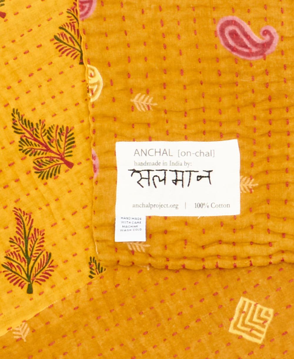 small kantha blanketwith signature of the maker on the tag