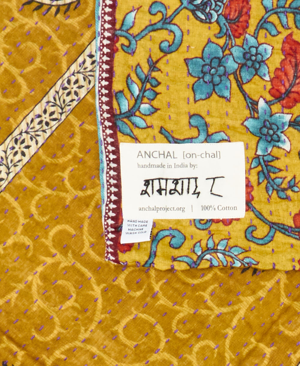 small kantha blanket with signature of the maker on the tag