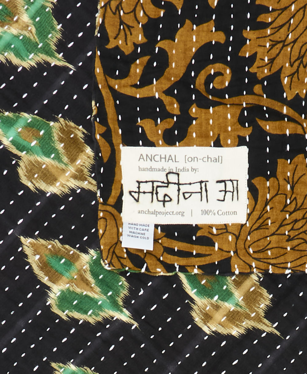 small kantha blanket with signature of the maker on the tag