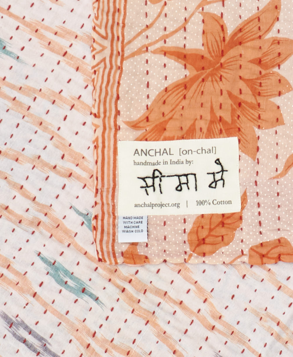 small kantha blanket with signature of the maker on the tag