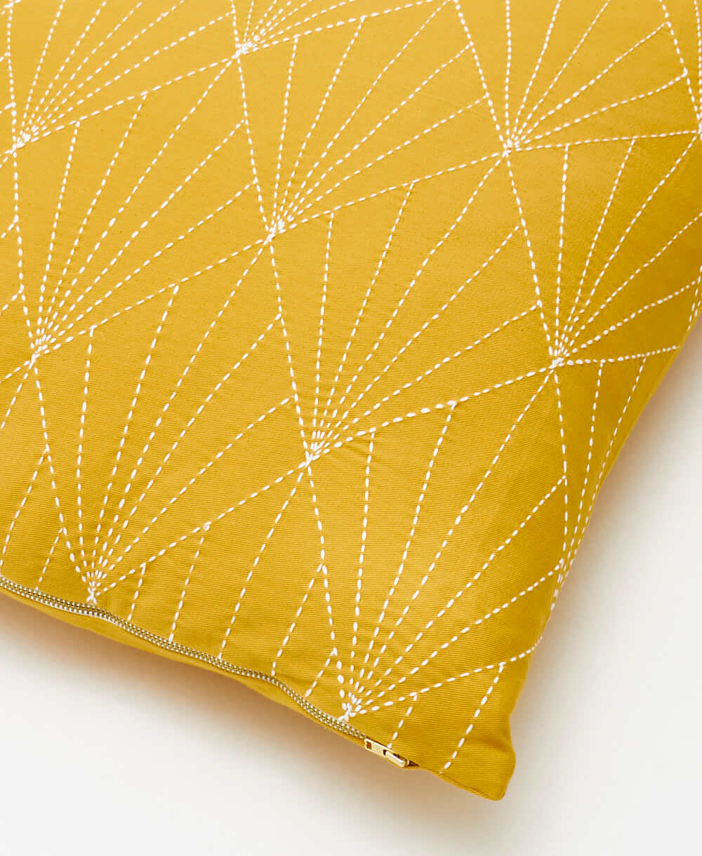 Yellow pillow with white geometric pattern on a light background