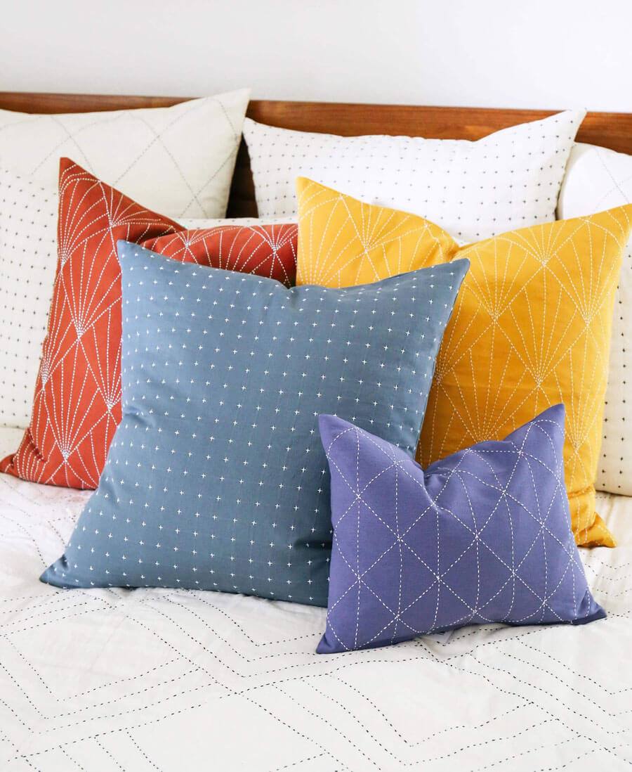 Colorful pillows on a bed with a wooden headboard