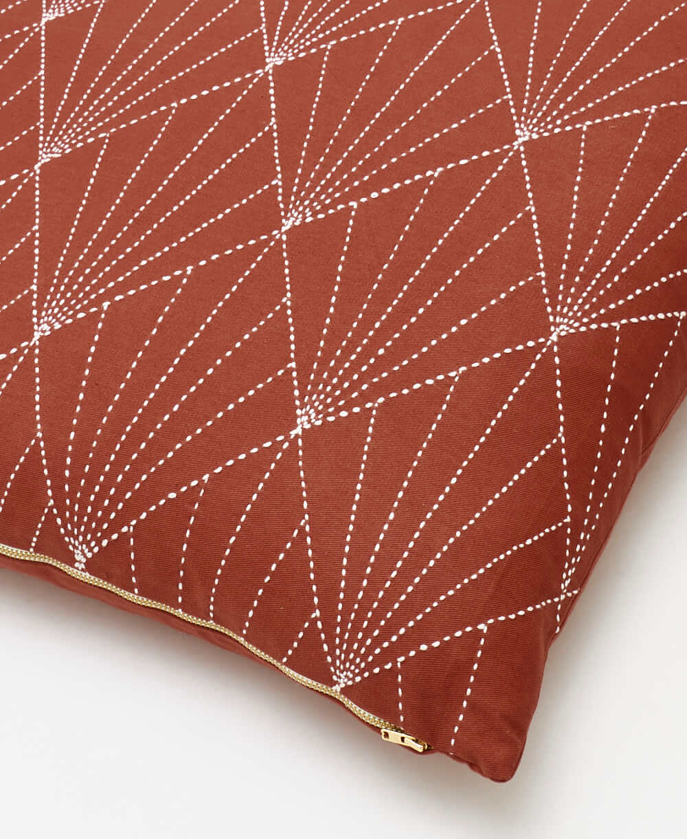brass-tone zipper closure on rust red array throw pillow