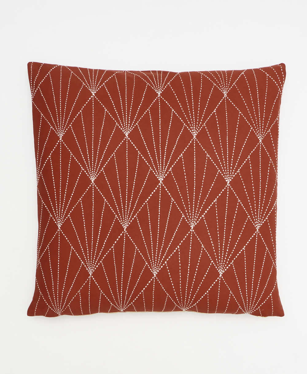 rust red modern throw pillow with white hand-stitched embroidery in an art deco pattern