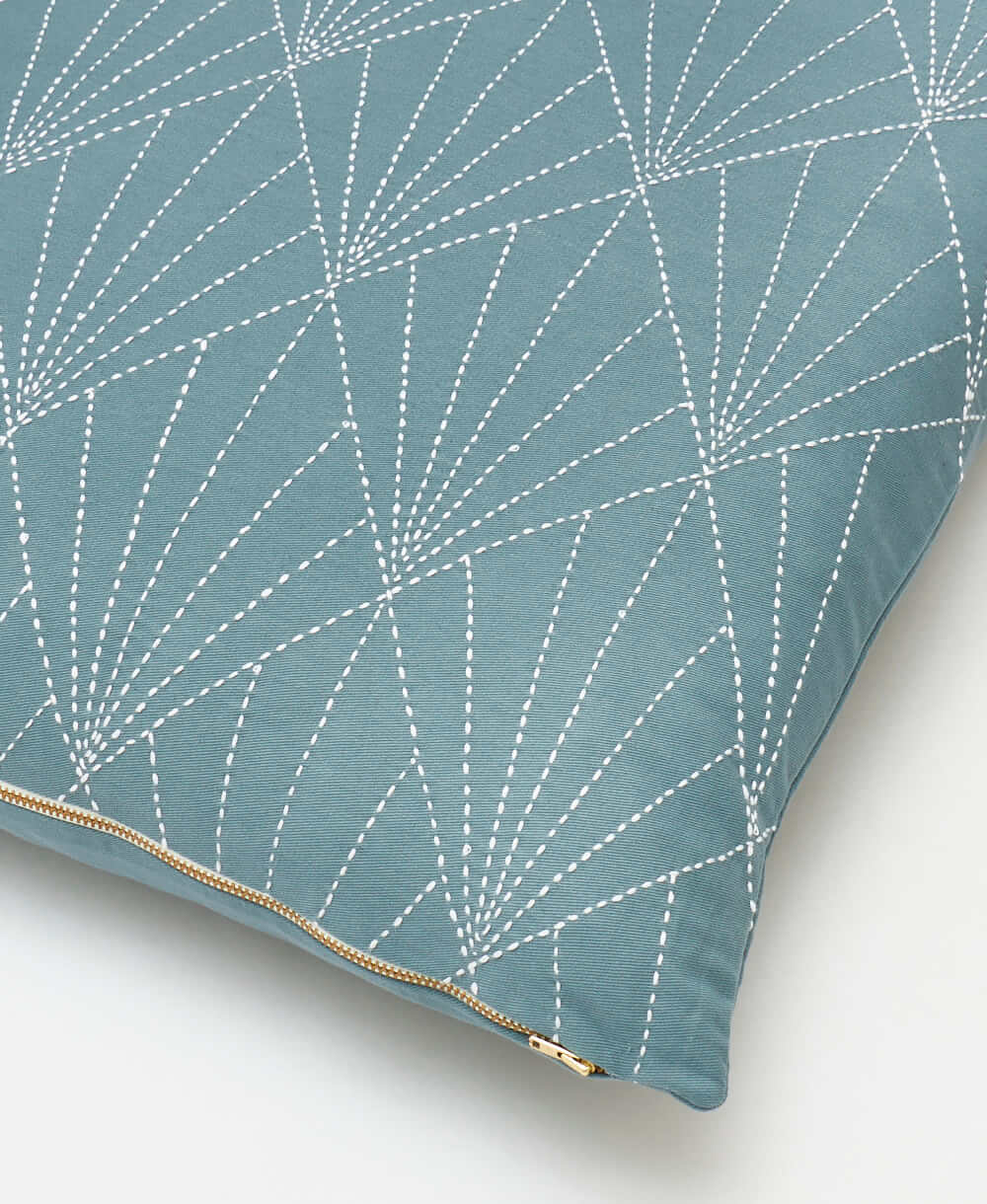 close-up of spruce green array throw pillow with textured white embroidery and brass-tone exposed zipper closure