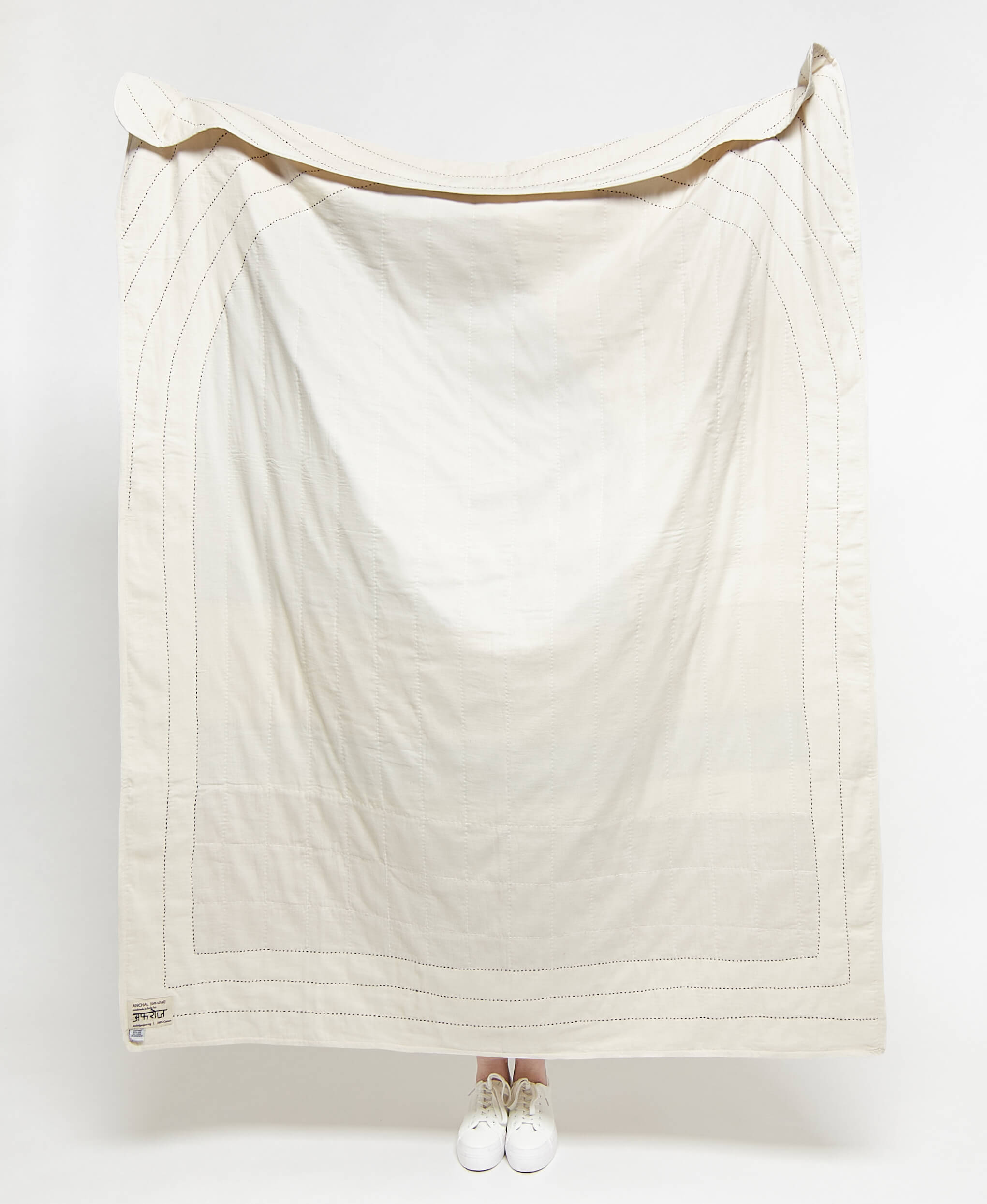 White quilt draped over a person on a white background