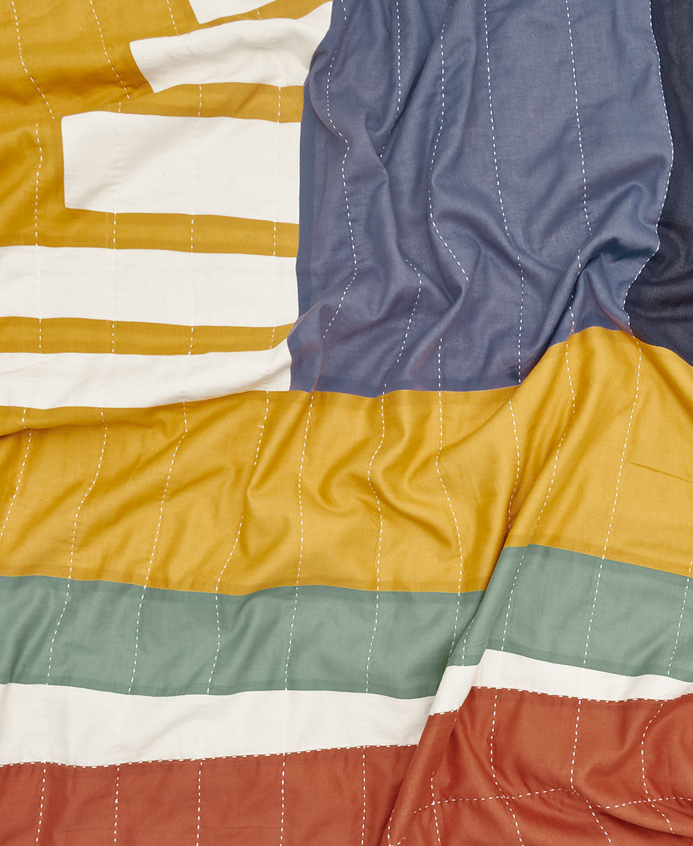 ascend patchwork quilt close up with hand-stitched white kantha embroidery