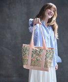 woman holding canvas mini tote bag in pink straps and a pink and green block print floral print