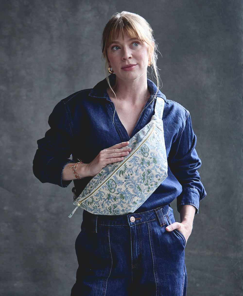 woman wearing all denim outfit with blue floral crossbody sling bag with adjustable strap