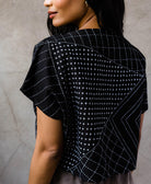 detail of delicate hand embroidery on black box crop top