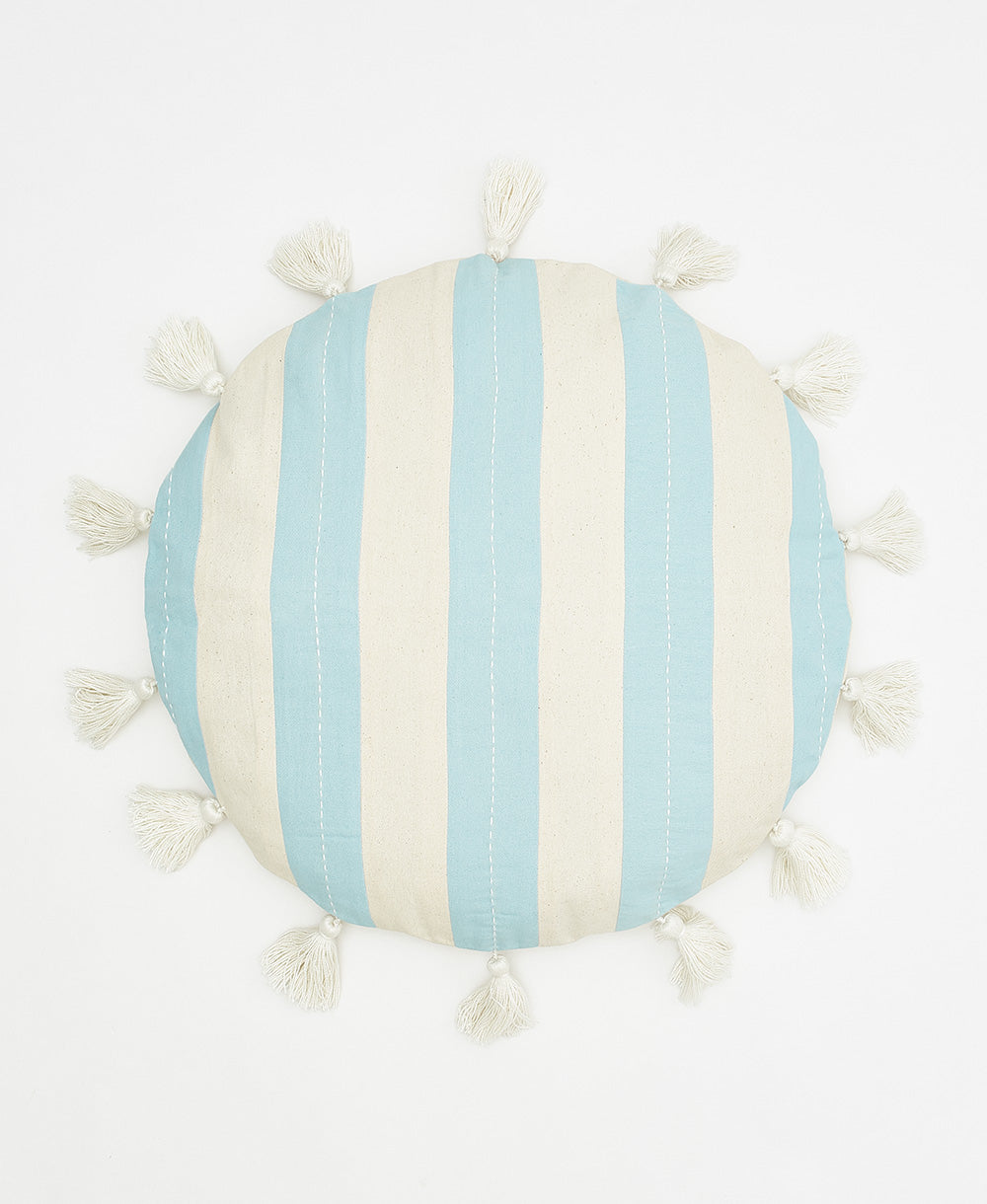 Round pillow with blue and white striped pattern and tassels on a white background