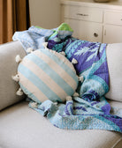Colorful quilt and striped pillow on a gray sofa