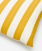 Close-up of a yellow and white striped pillow on a white background