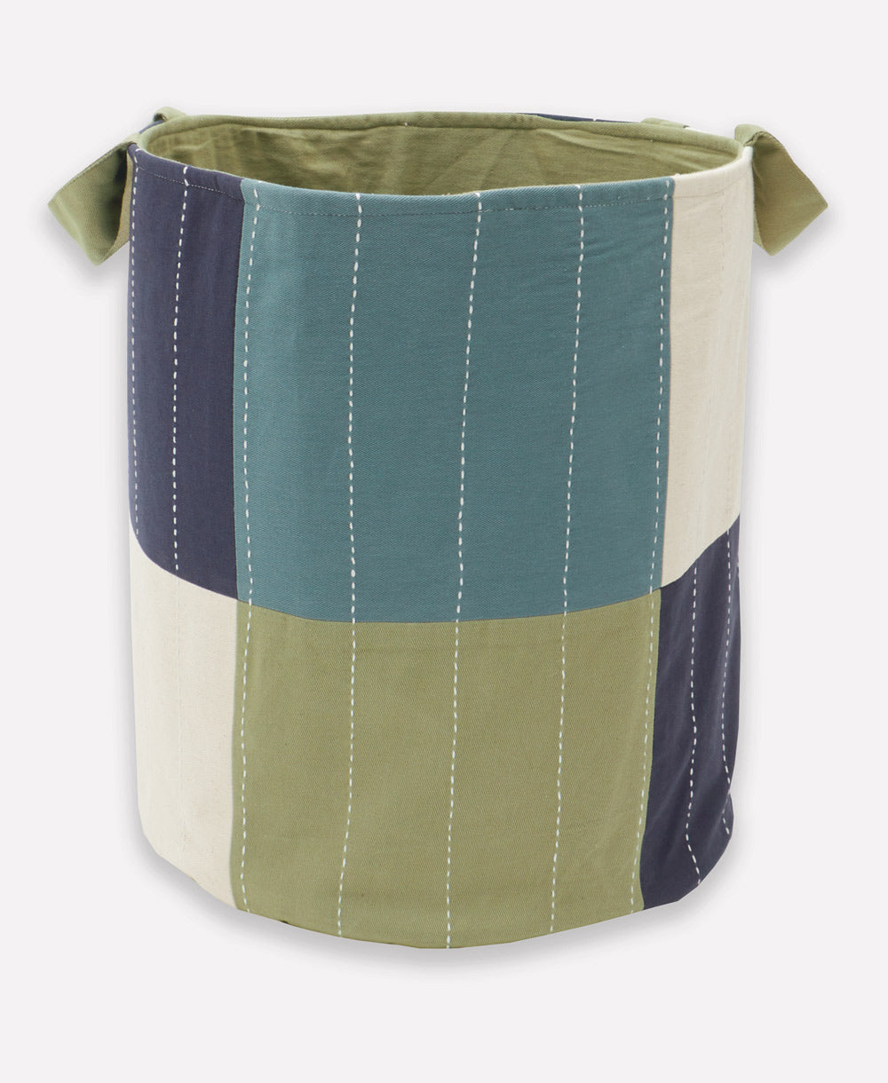 Multicolored fabric storage bin with green, blue, and beige sections on a white background