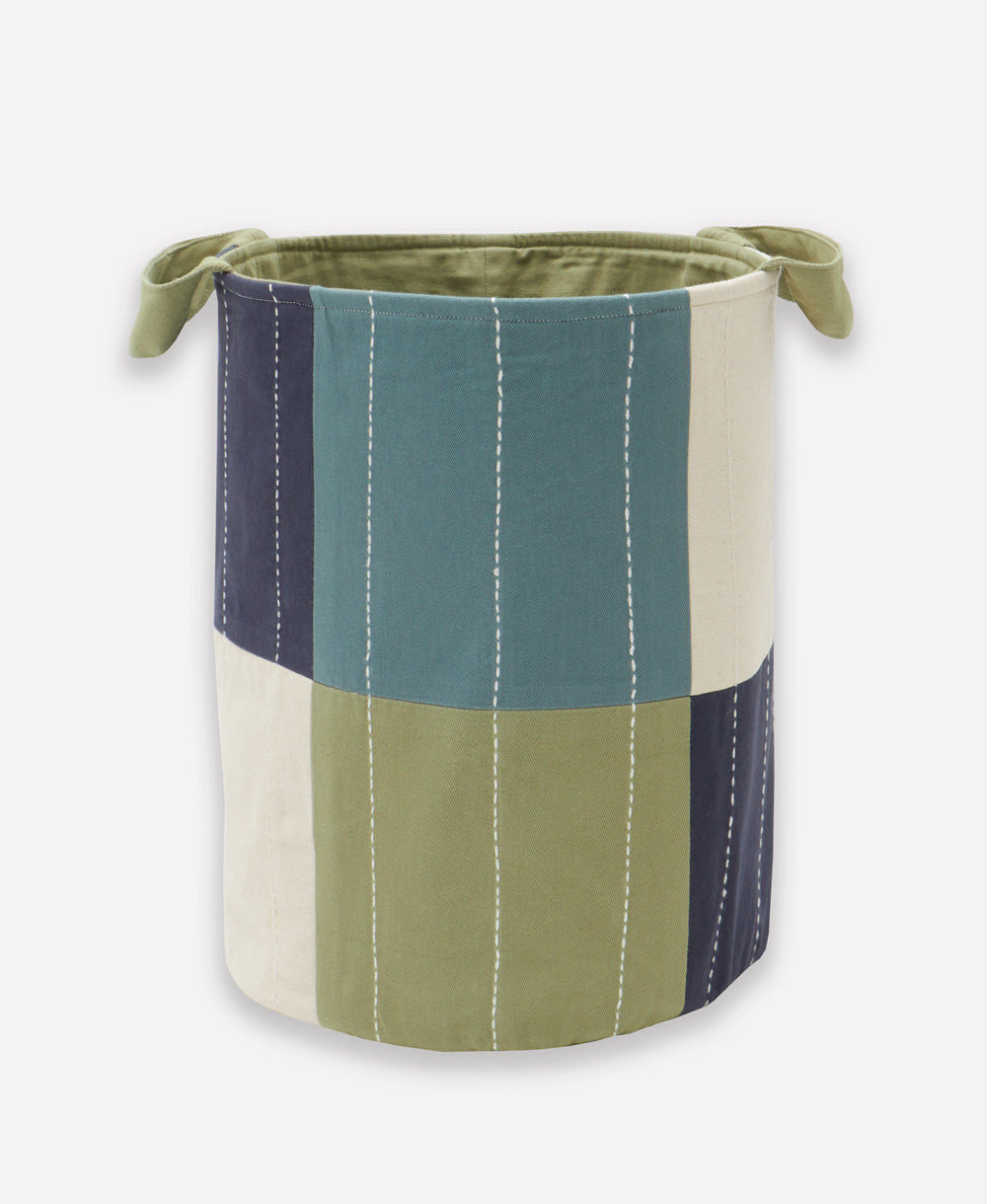 Fabric storage bin with green, blue, and beige color block design on a white background