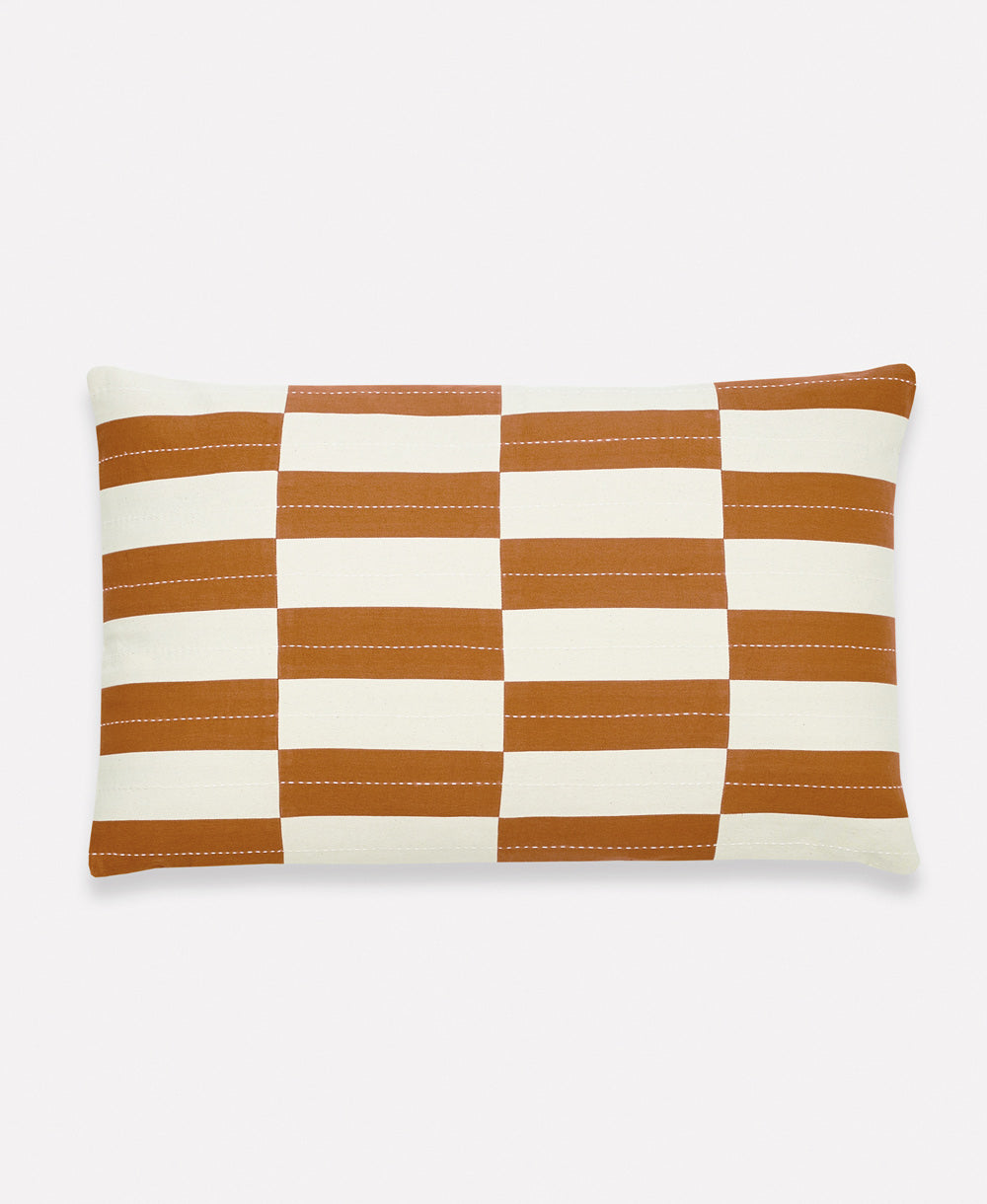 Checkered pillow with brown and white stripes on a light gray background