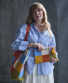 woman holding checkered pouch and checkered matching tote bag