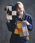 woman holding collection of canvas-lined checkered pouches in different colorways