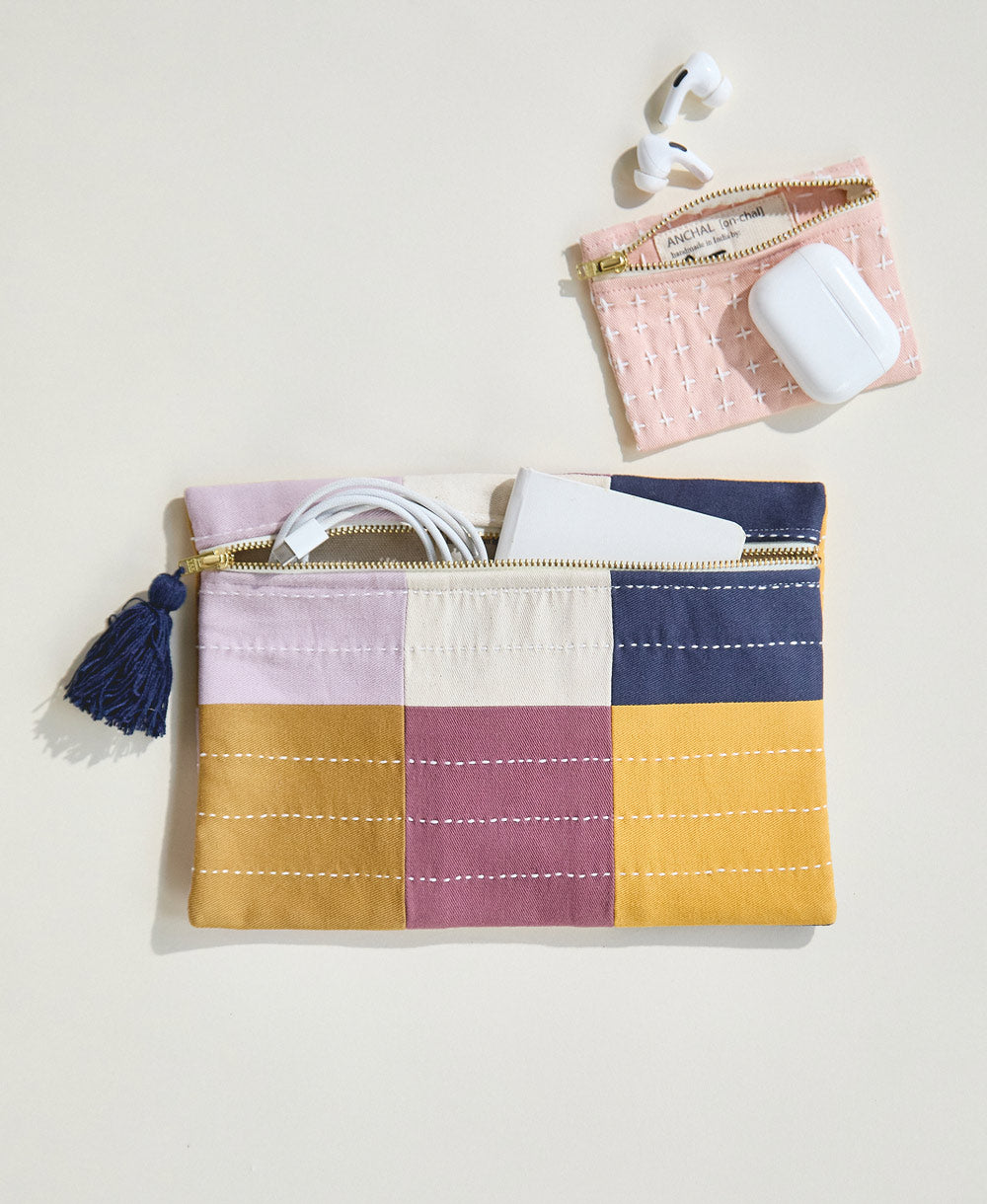 small lilac checkered pouch clutch with pink cross-stitch coin purse holding chargers and headphones