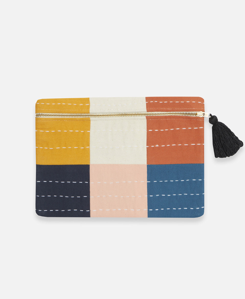 small checkered pouch in orange, mustard yellow, bone, pink, navy blue and cobalt blue with a black tassel