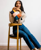 woman holding small checkered pouch clutch with a black tassel