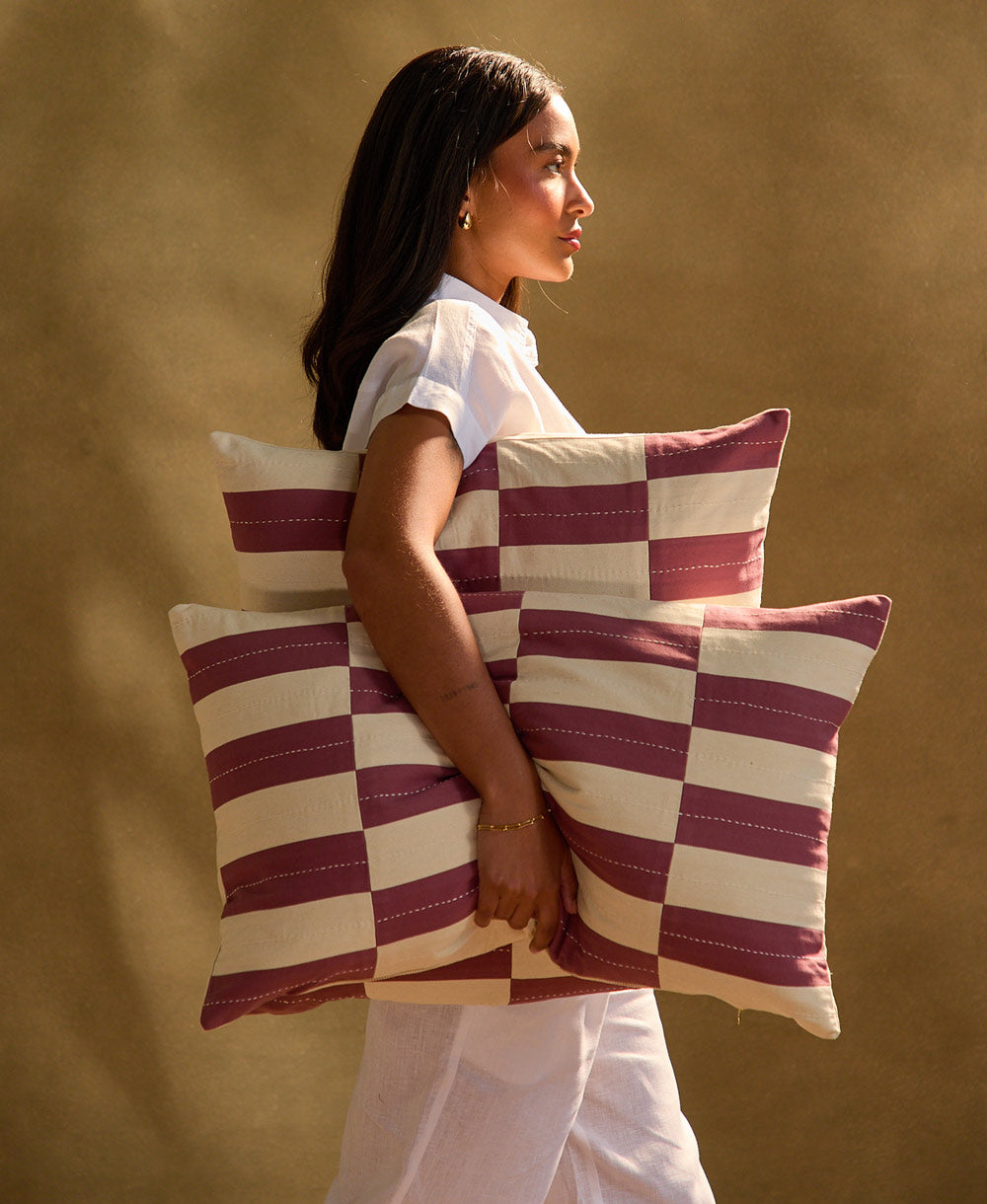woman hold berry checkered pillows