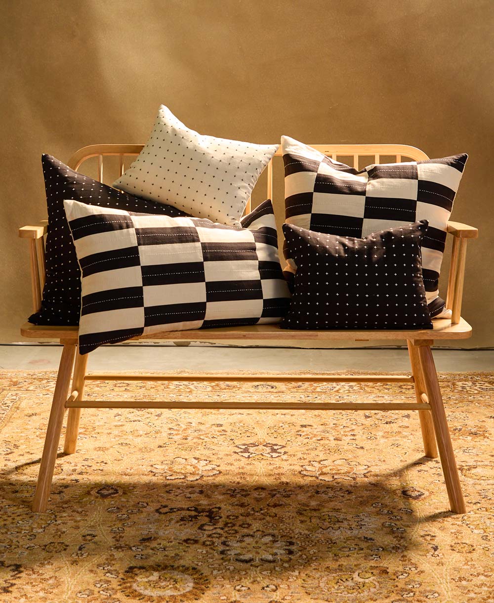 black and white pillows on a wooden bench