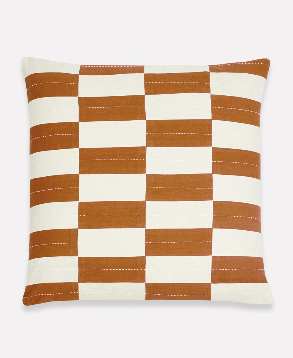 Checkered pillow with brown and white stripes on a light gray background