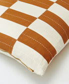 checkered pillow with brown and white stripes on a light background made from organic cotton