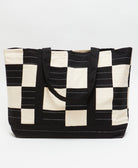 canvas checkered tote bag with black shoulder straps and white hand-stitched embroidery
